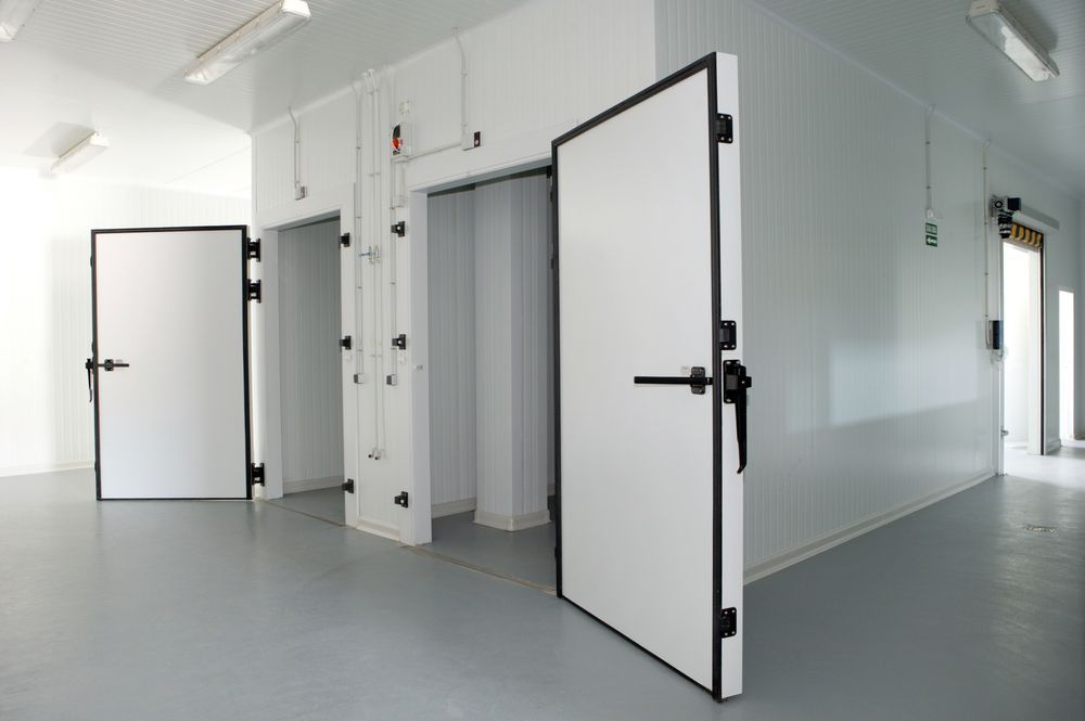 Three White Doors Are Open In A Room With A Gray Floor — NQ Fridge & Freezer Seals In Manoora, QLD