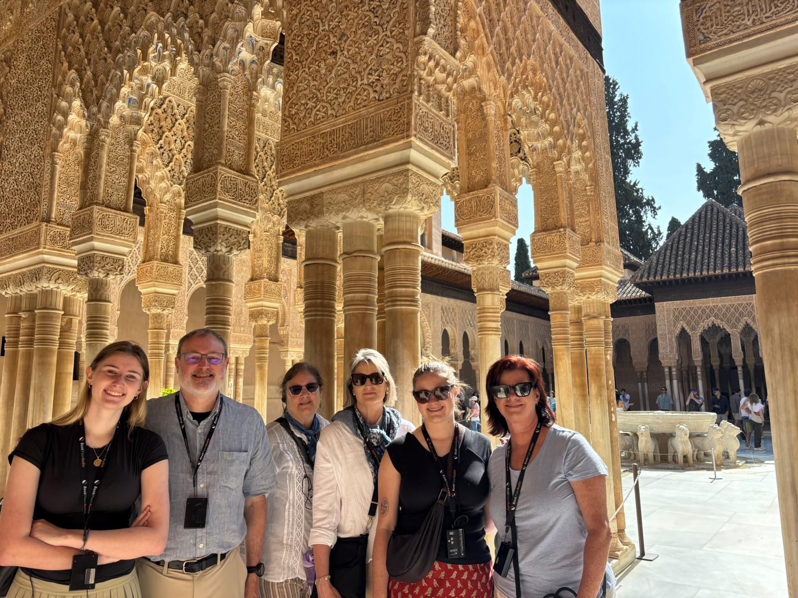 Dianna Suggs with guided tour of the Alhambra Court of the Lions 
Granada with arches in the foreground 