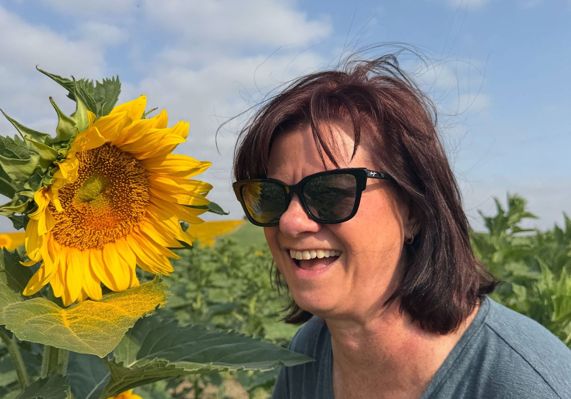 Dianna Suggs and a giant Sunflower with blue sky in Andalusia
