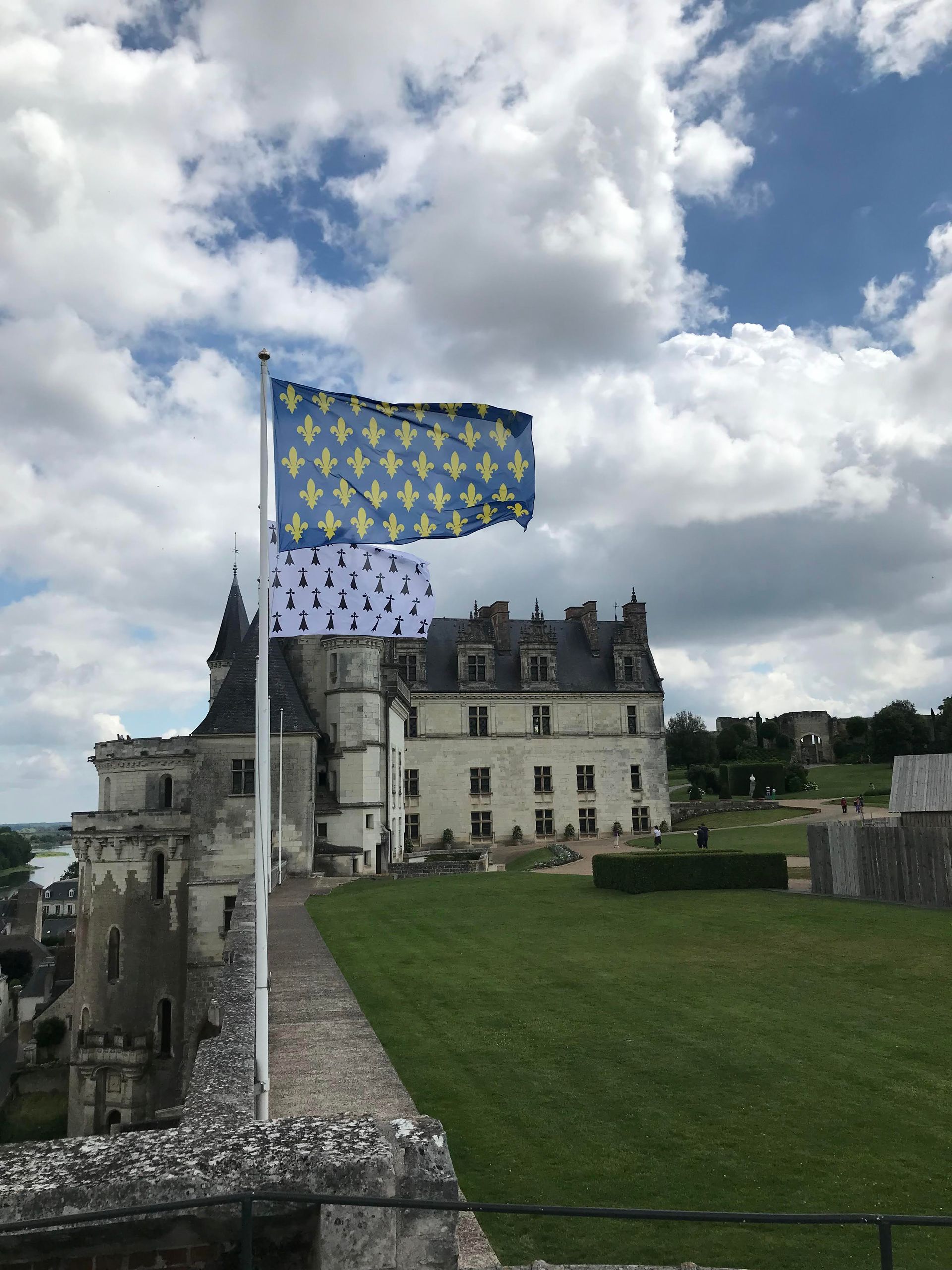 Chateau Amboise with 2 flags and a cloudy blue sky. Dianna Suggs Travel LL specializes in customized travel for families 