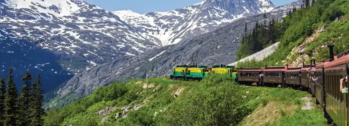 Train along the mountains in Skagway with back ground of glaciers and moutains 