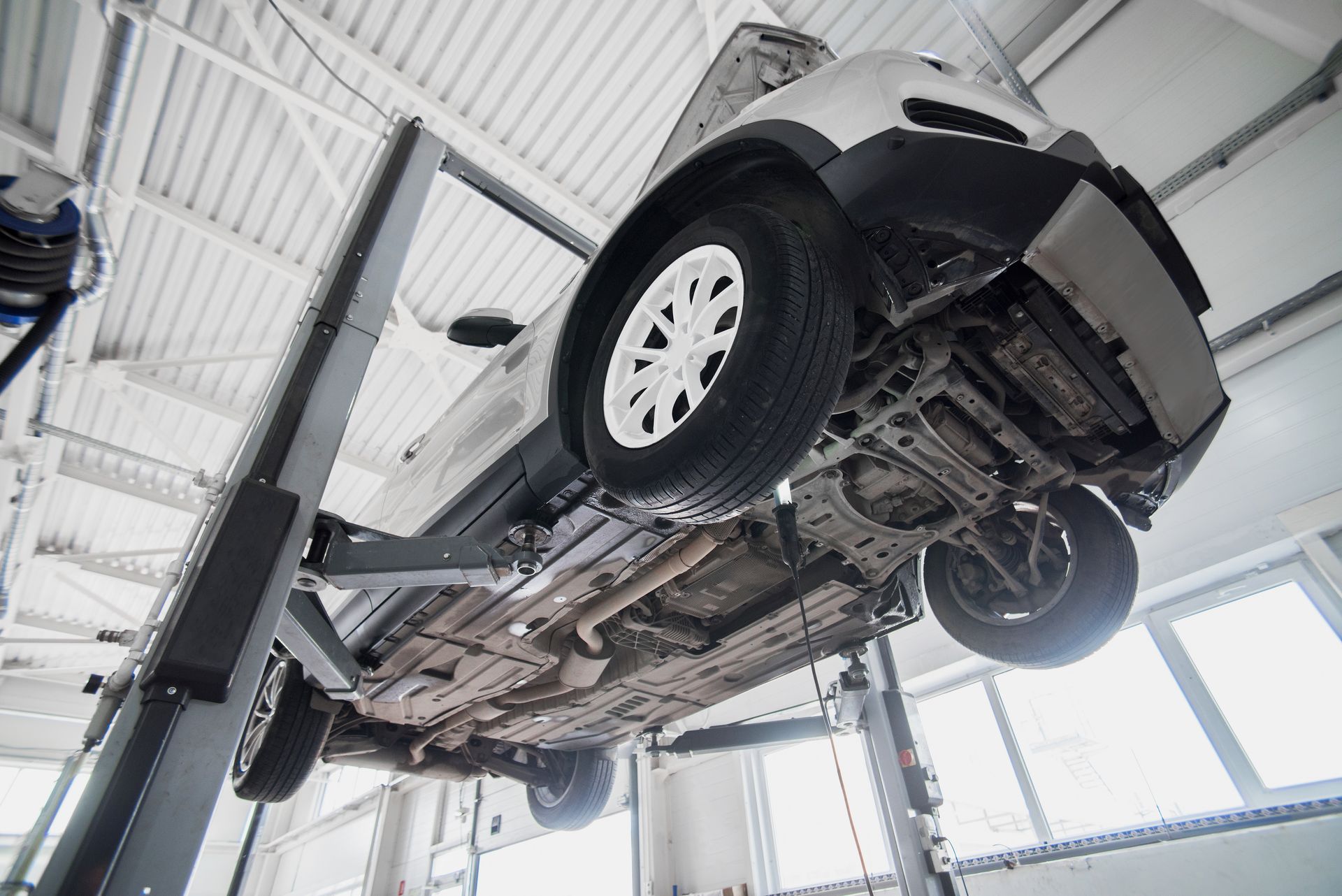 A Car Is Sitting On A Lift In A Garage— Brad's Auto Electrical in Mareeba, QLD