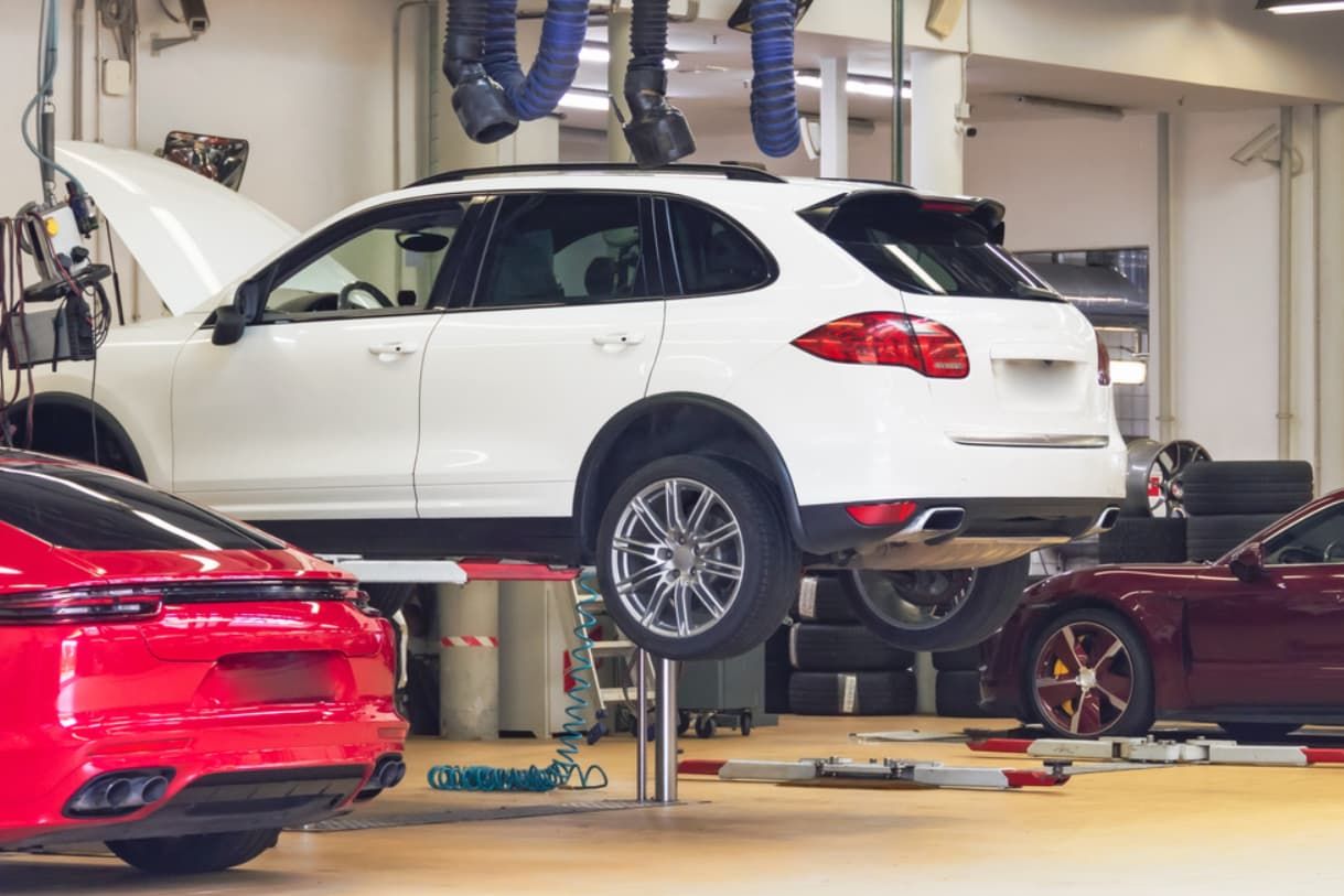 A White Car Is Sitting On Top Of A Lift In A Garage — Brad's Auto Electrical in Mareeba, QLD