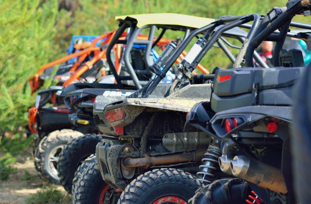 A Row Of Atvs Parked Next To Each Other On A Dirt Road — Brad's Auto Electrical in Mareeba, QLD