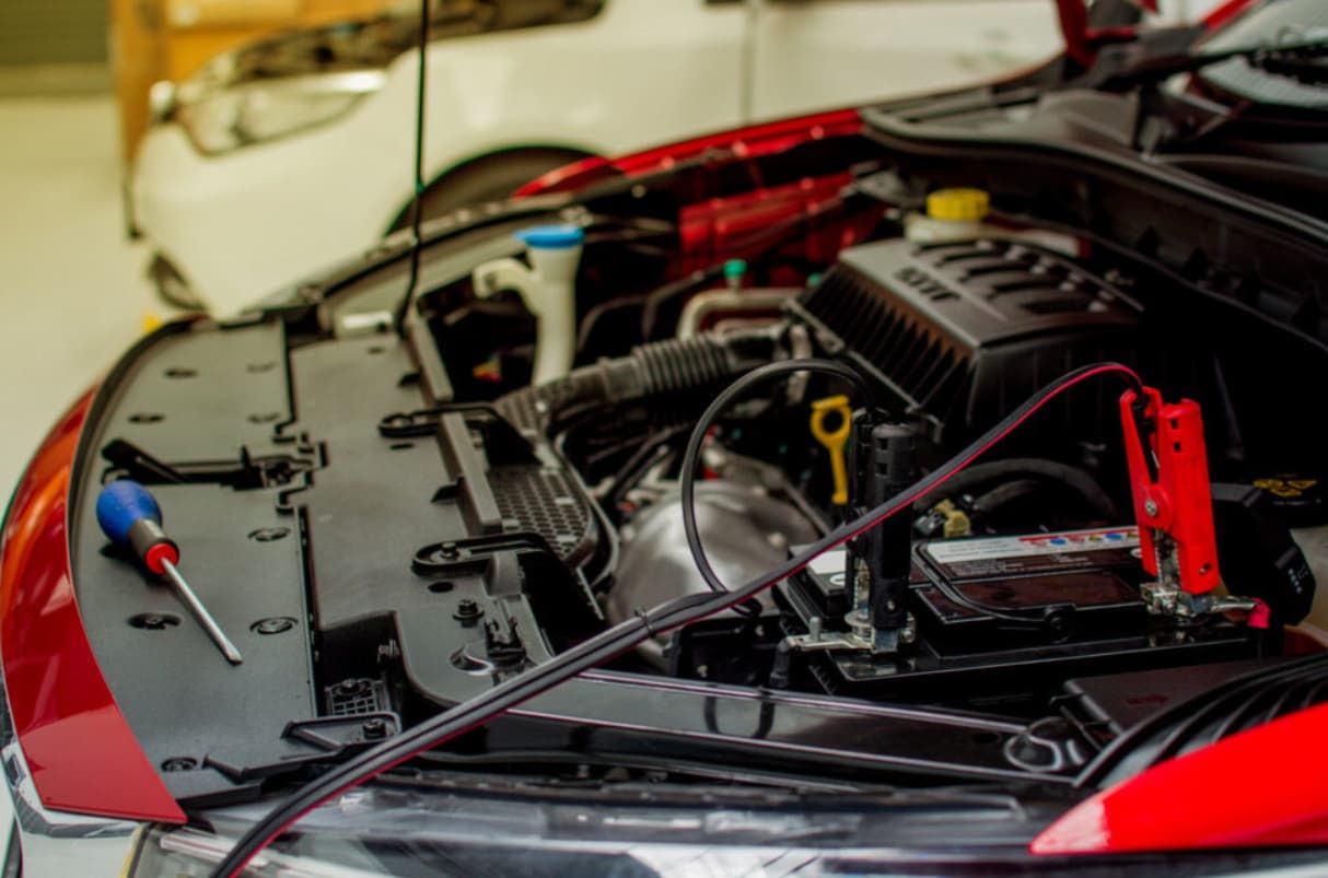 The Hood Of A Car Is Open And A Battery Is Being Charged — Brad's Auto Electrical in Mareeba, QLD