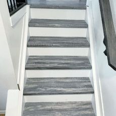 A set of stairs with wooden steps and a white railing