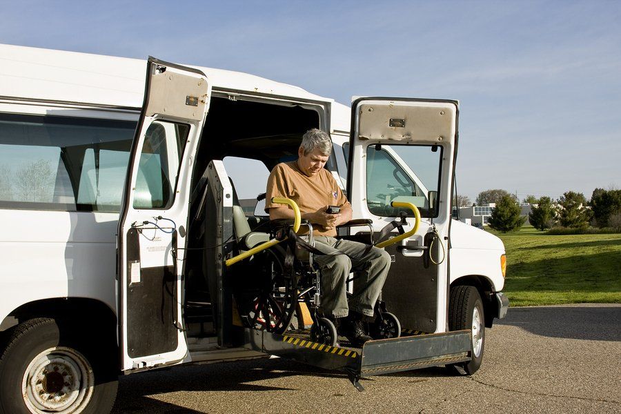 man with wheelchair beside the van