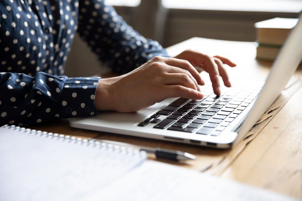 Person Typing on A Laptop Seated at A Desk — Careful Books in Westcourt, QLD