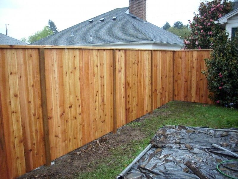 A wooden fence with a house in the background