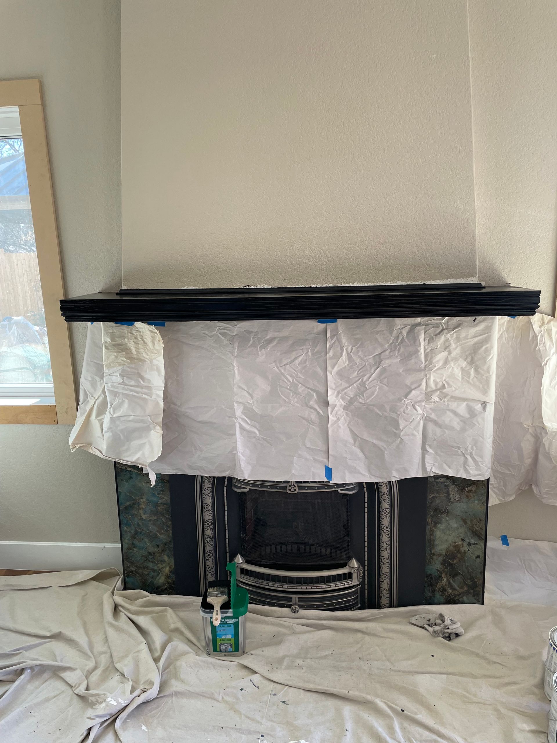 Living room fireplace under renovation, covered with paper and plastic sheeting