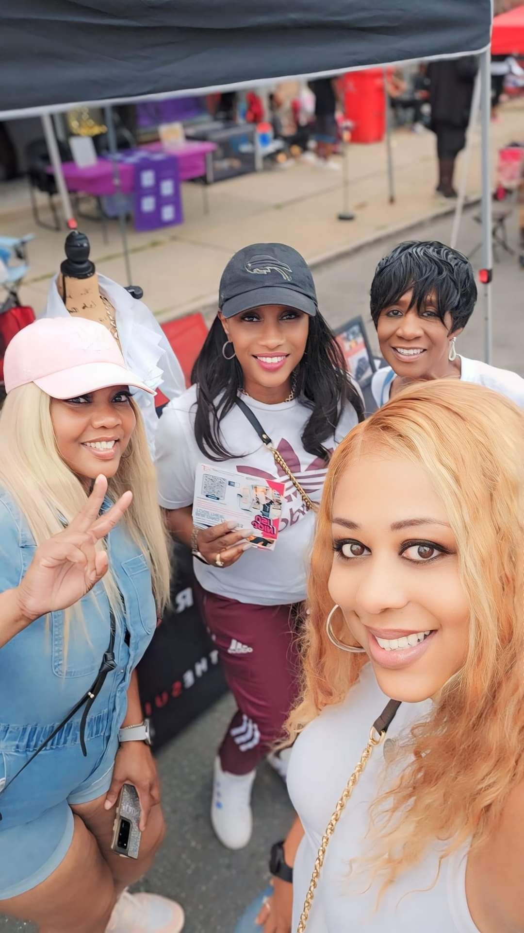 A group of women are posing for a picture in front of a tent.