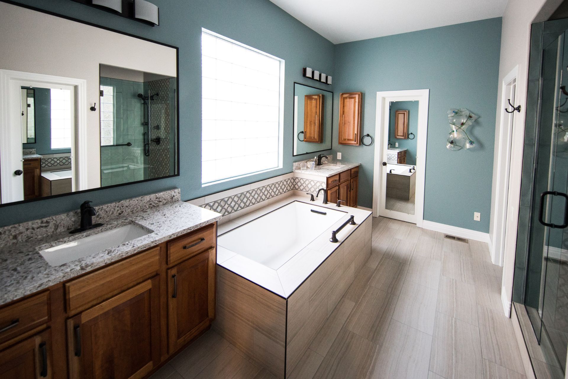 A bathroom with a bathtub , sink , and mirrors.