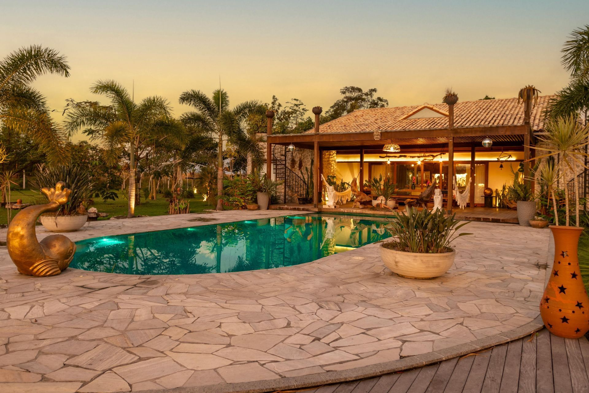There is a large swimming pool in front of a house.
