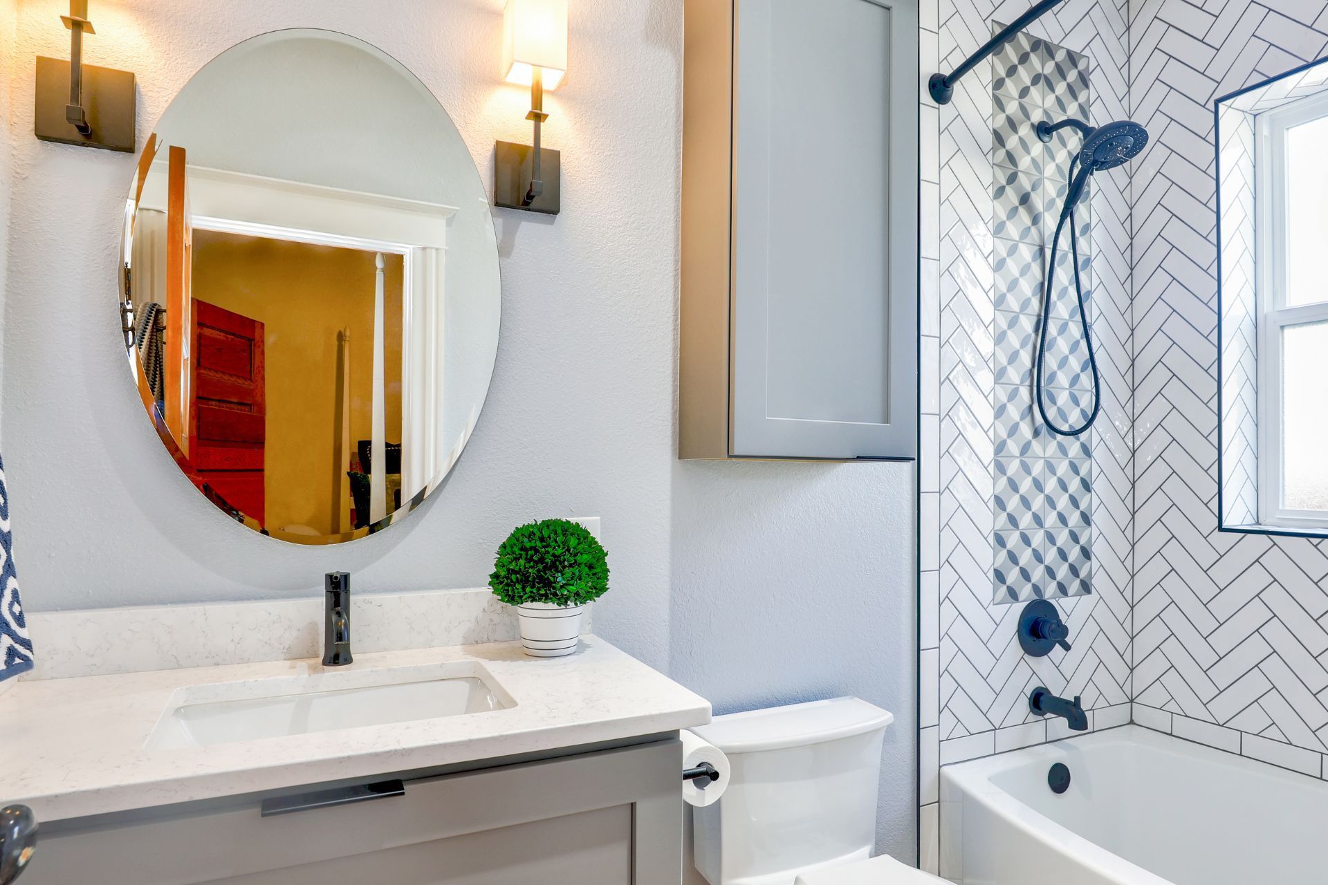 A bathroom with a sink , toilet , bathtub and mirror.