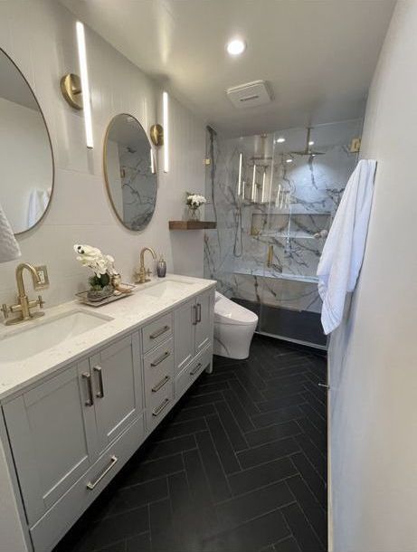 A bathroom with two sinks , a toilet , and a shower.