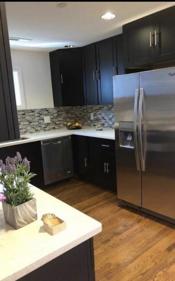 A kitchen with stainless steel appliances and black cabinets