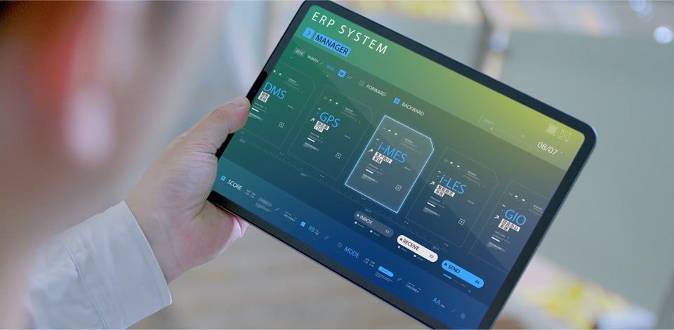 Person holding a tablet showing a blue-green dashboard interface in landscape orientation