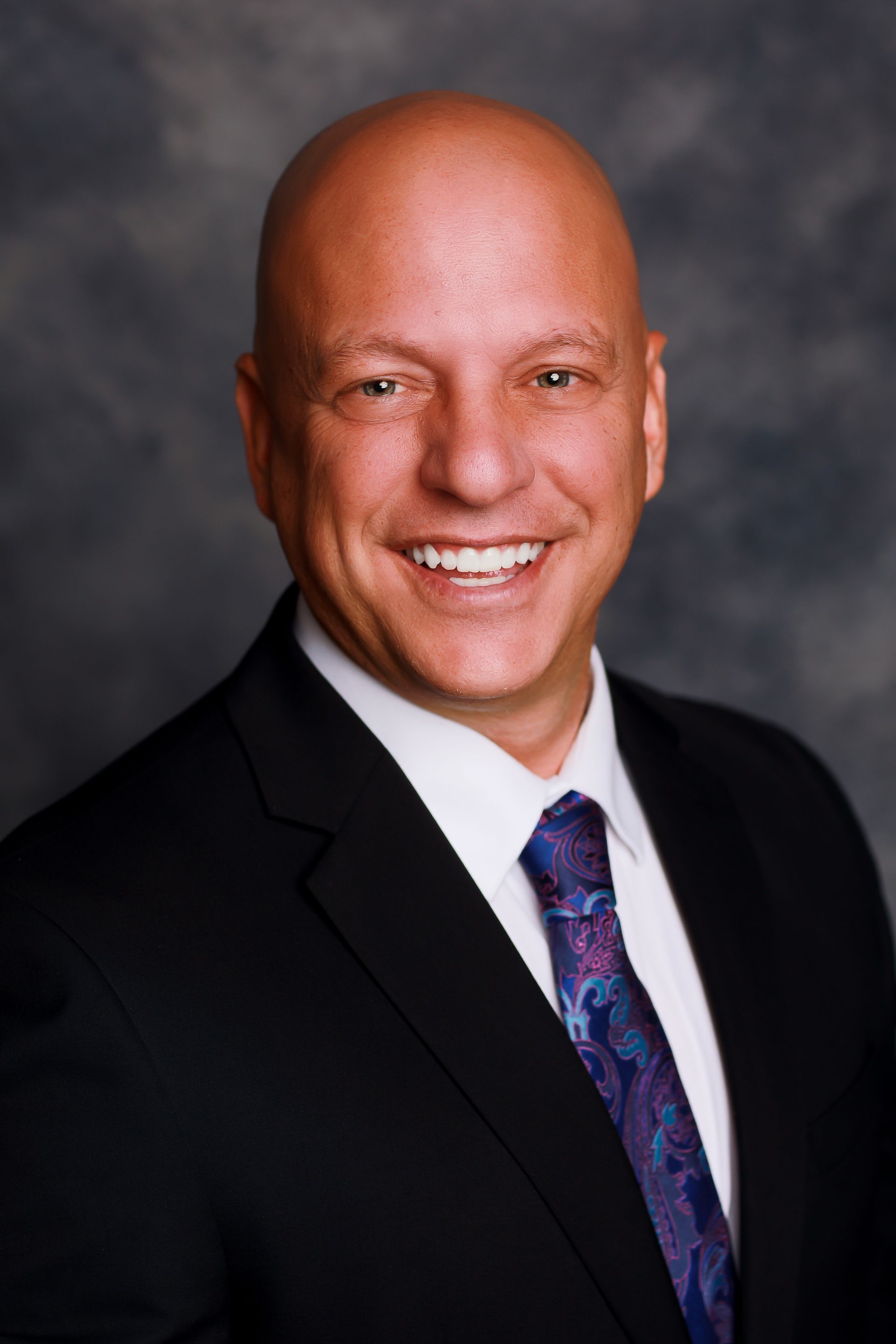 A man in a suit and tie is smiling for the camera.