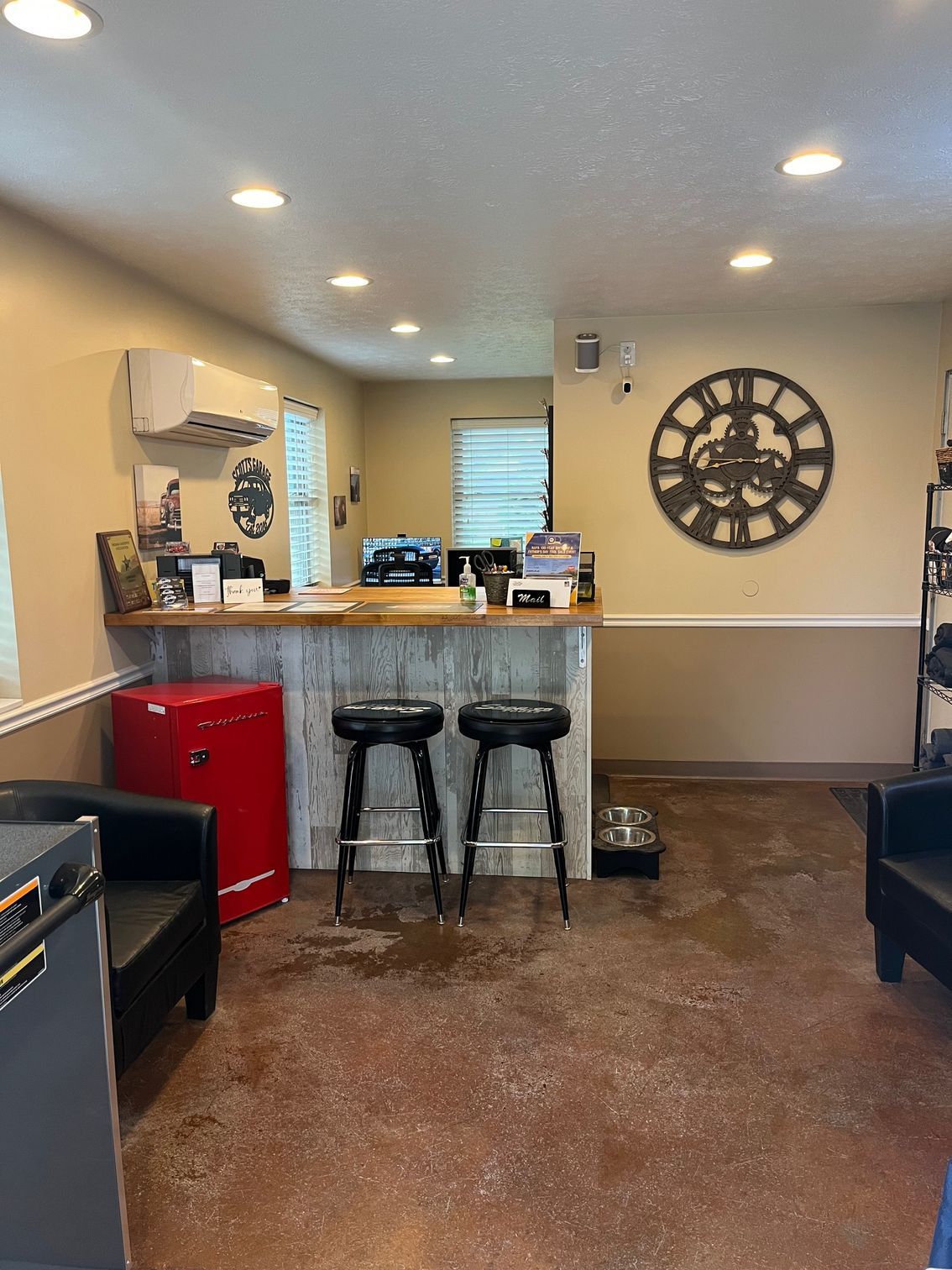 A small business waiting area with a counter, stools, and a red mini fridge. | Scott's Garage
