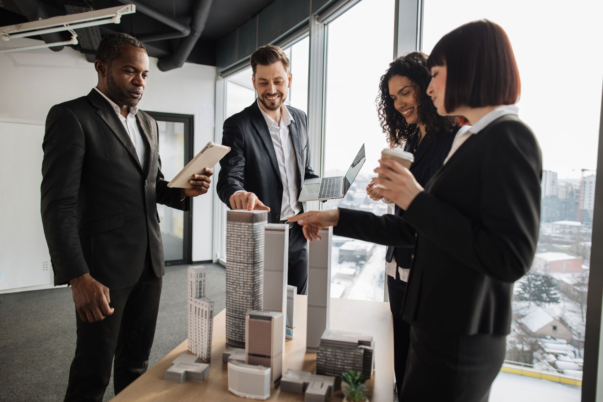 Businesspeople review architectural models in an office.