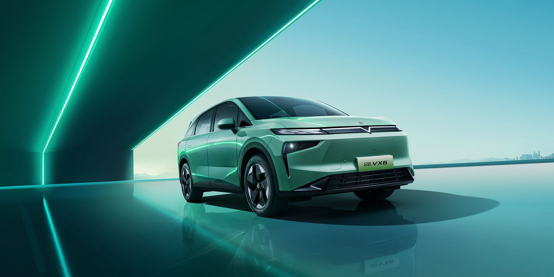Green electric vehicle in a teal setting.