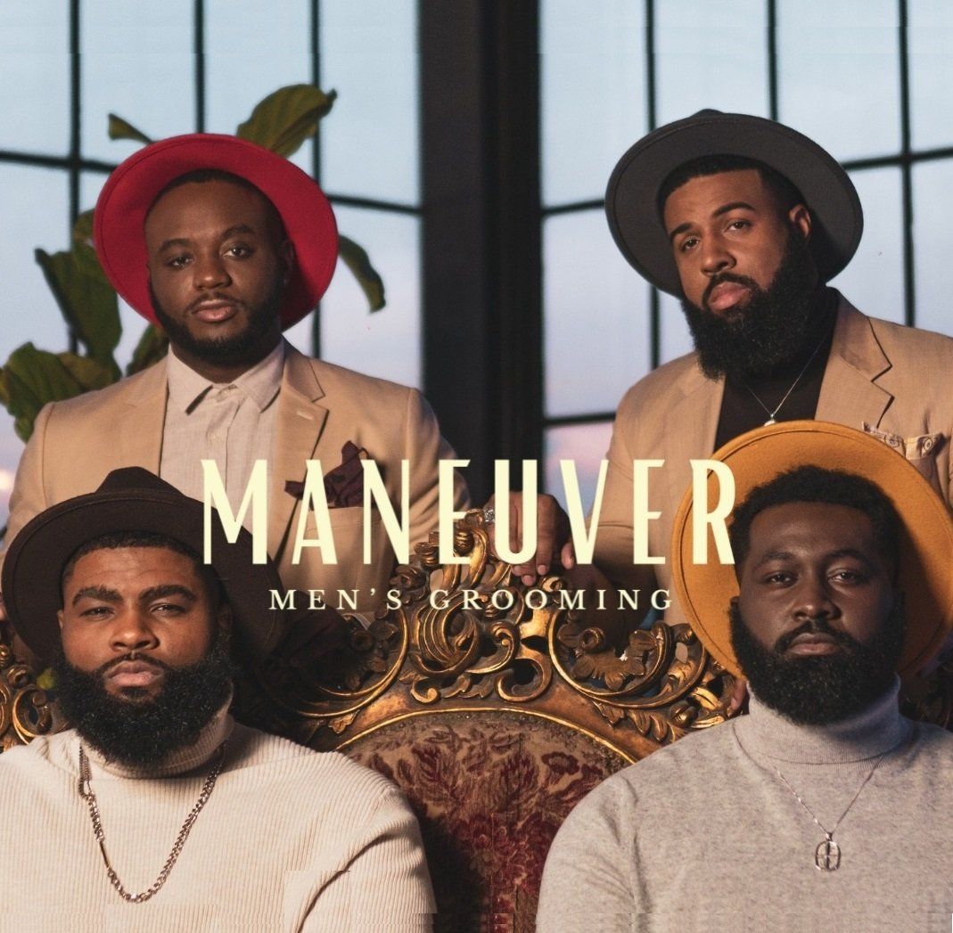 A group of men sitting in front of a window with the words maneuver on the bottom