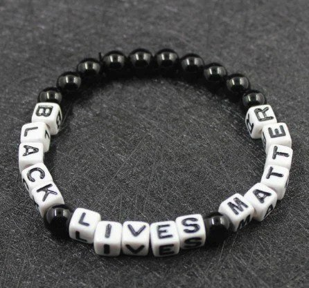 A black and white bracelet with the words `` black lives matter '' written on it.