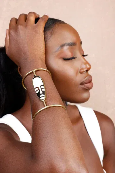 A woman wearing a bracelet with a face on it