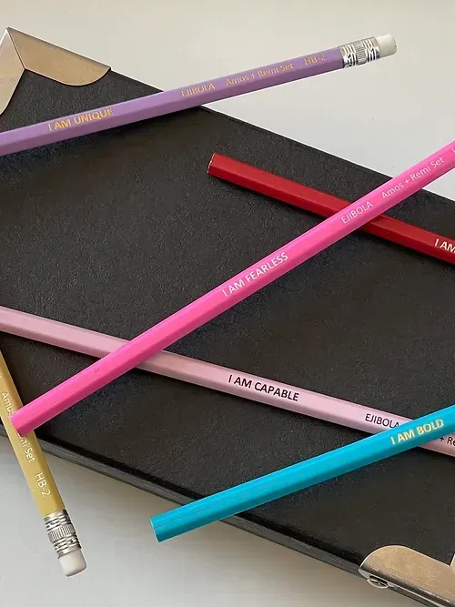 A bunch of pencils are laying on top of a notebook
