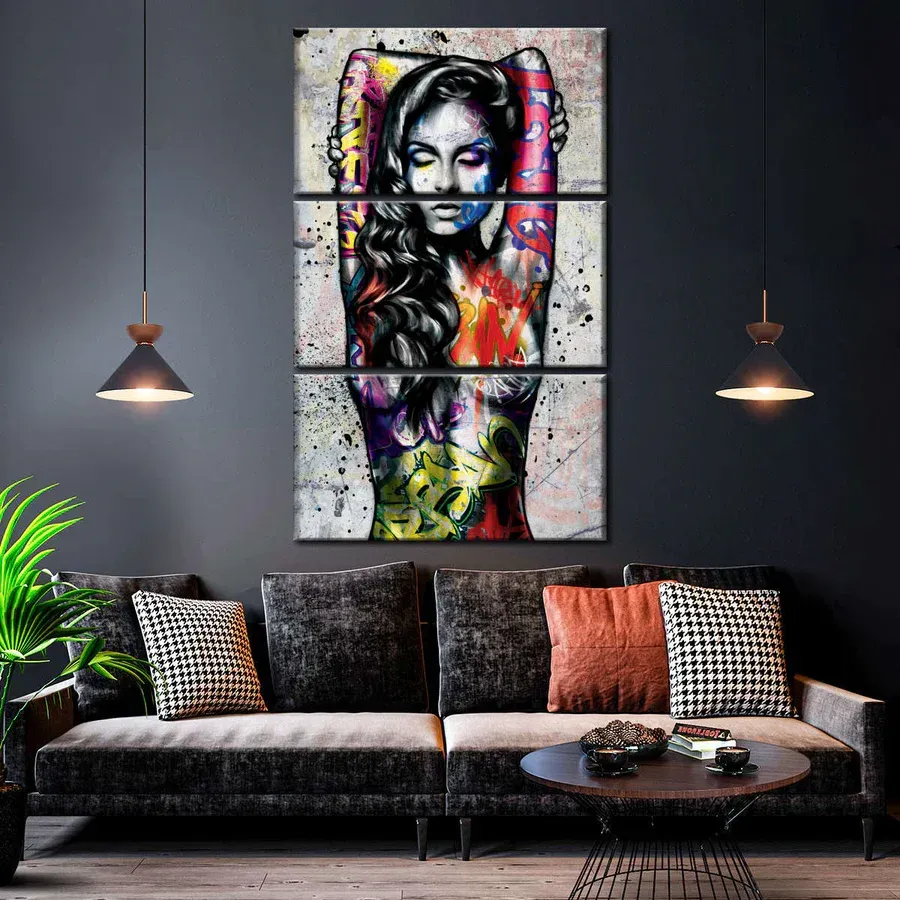 A living room with a couch and a painting of a woman on the wall.