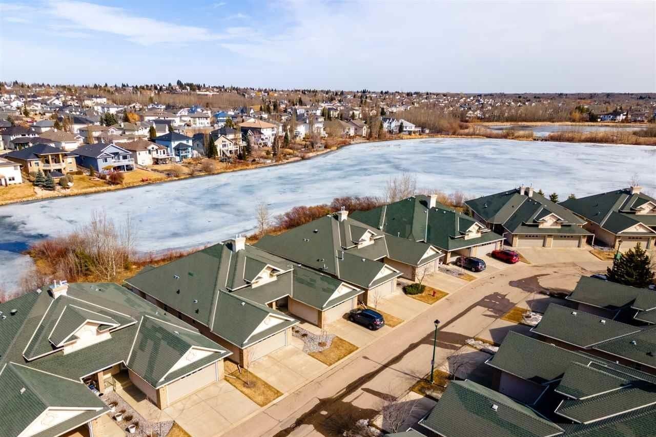 An aerial view of a residential area with a lake in the background.