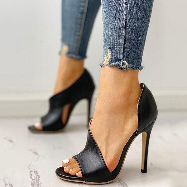 A woman wearing a pair of black high heels and jeans.