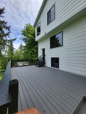 Freshly painted white home with new exterior siding and deck