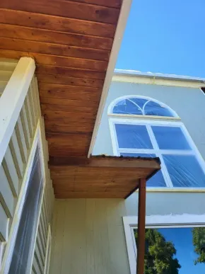 Natural wood porch ceiling with freshly stained soffit and beams