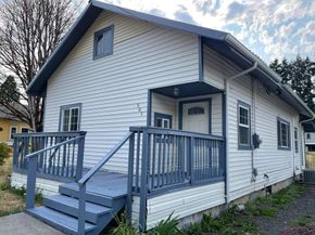 Residential exterior painting with blue trim and freshly painted deck