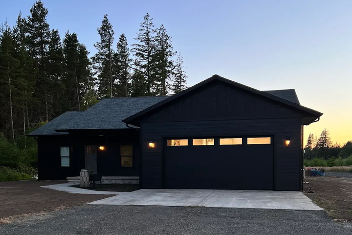 Home exterior painted dark charcoal, illuminated at dusk in Centralia, WA