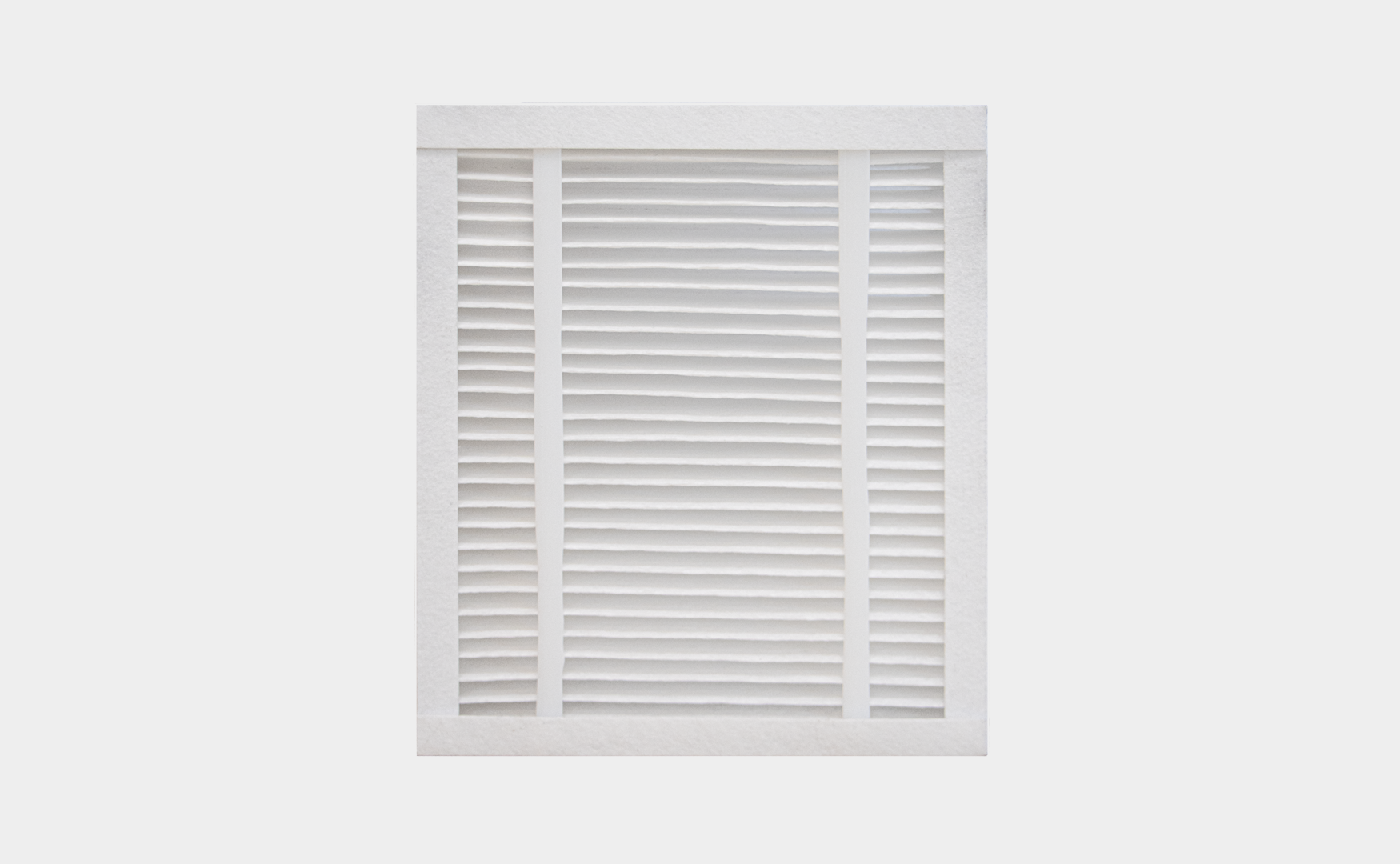 Pleated HVAC air filter on a light grey background, illustrating optimal air filtration and improved indoor air quality.