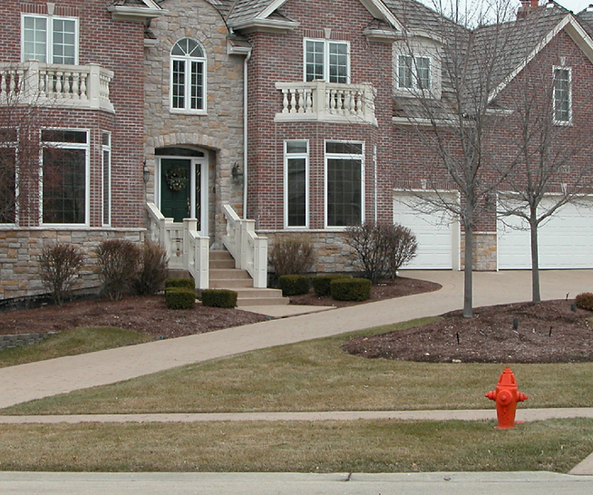 a large brick house with a fire hydrant in front of it