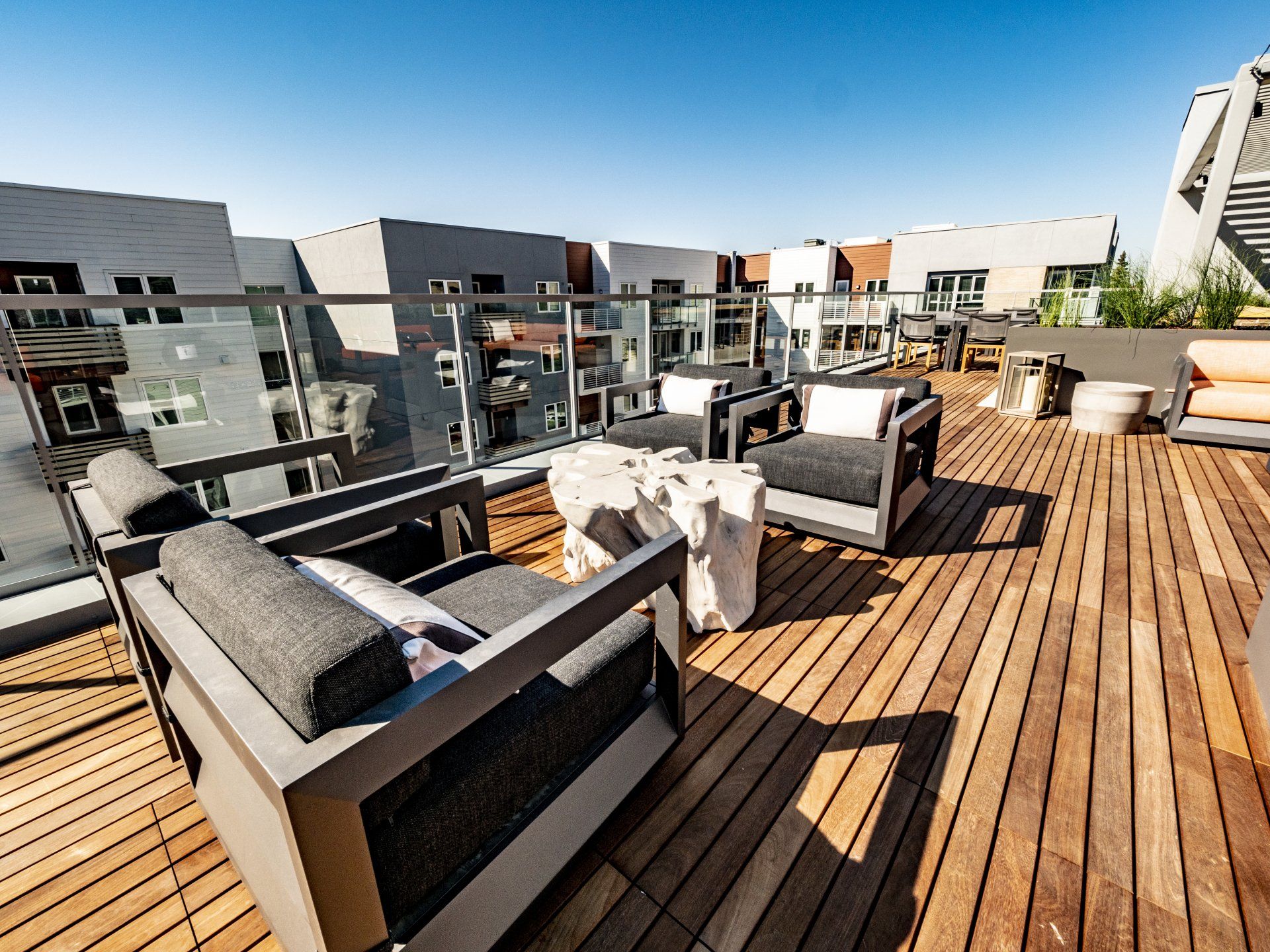 A wooden deck with chairs and a table on it at Capitol Towers.