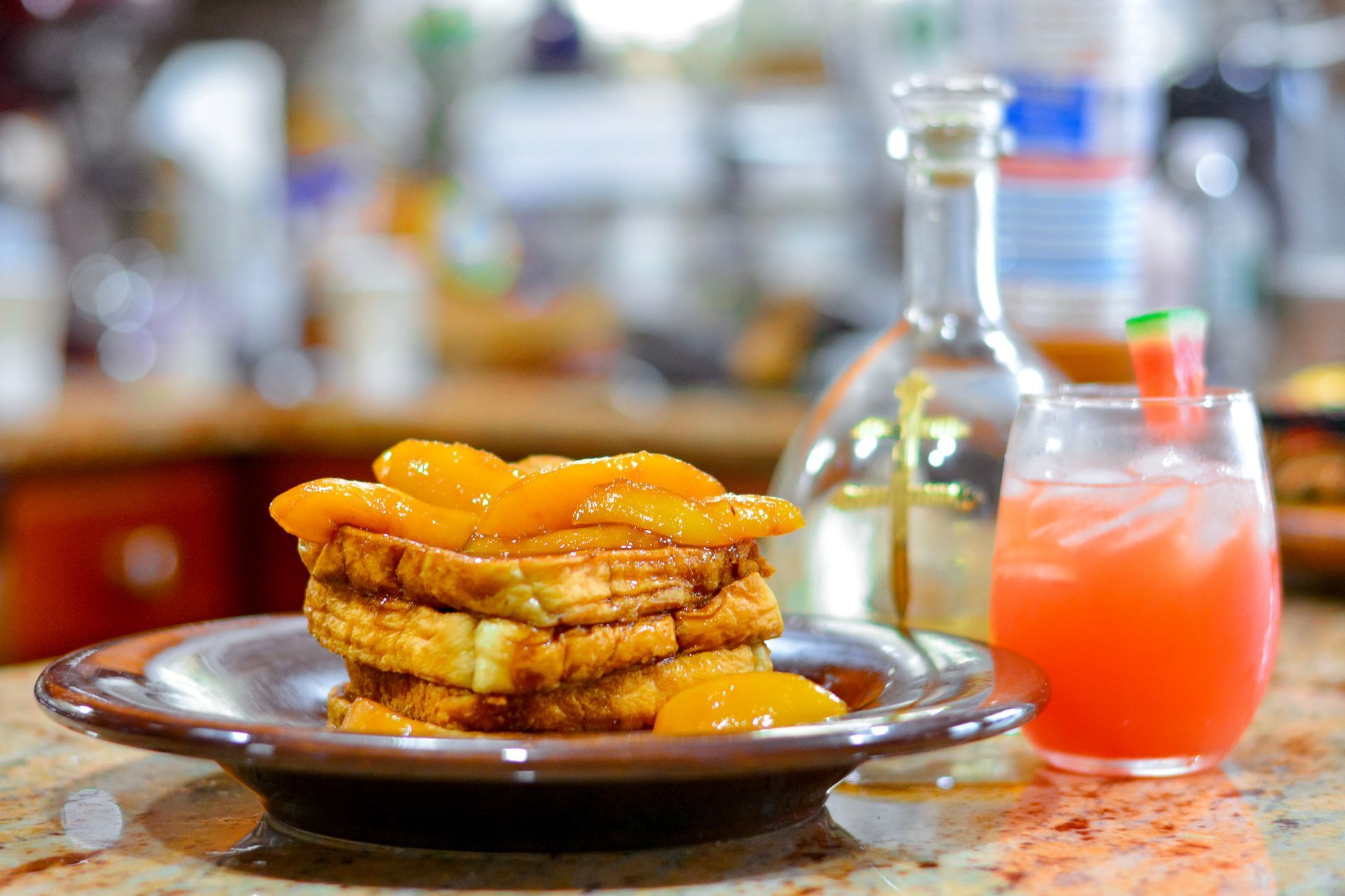 French toast with orange slices and a cocktail on a countertop.