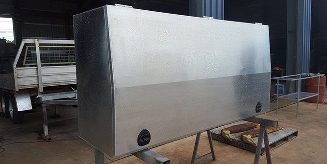 A Large Metal Box is Sitting on Top of a Wooden Table Next to a Truck — Roll Press NT In Tivendale, NT