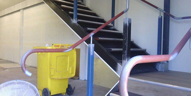 A Yellow Trash Can is Sitting Next to a Set of Stairs — Roll Press NT In Tivendale, NT
