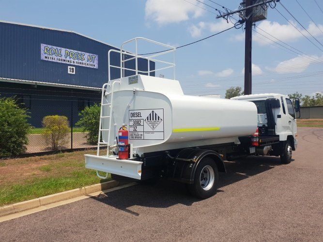 A White Tanker Truck is Parked in Front of a Building — Roll Press NT In Tivendale, NT