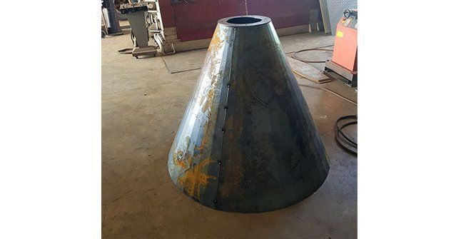 A Large Metal Cone is Sitting on the Floor in a Room — Roll Press NT In Tivendale, NT