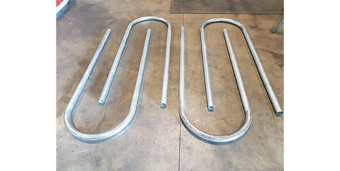 A Bunch of Metal Pipes Are Sitting on Top of a Wooden Table — Roll Press NT In Tivendale, NT