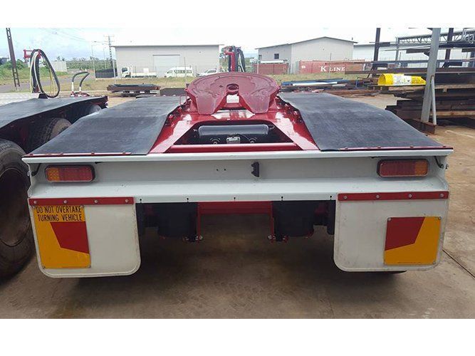 A Red Truck With a Trailer Attached to It is Parked in a Parking Lot — Roll Press NT In Tivendale, NT