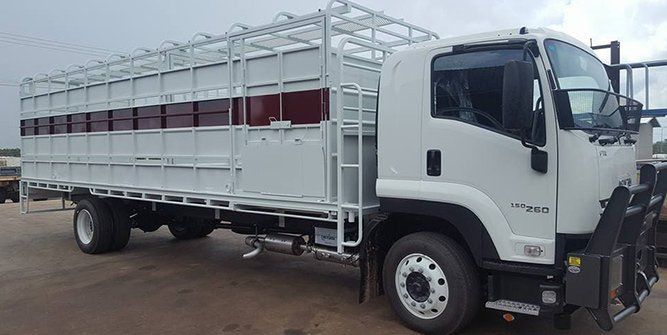 A White Truck With a Red Stripe on the Side is Parked in a Parking Lot — Roll Press NT In Tivendale, NT