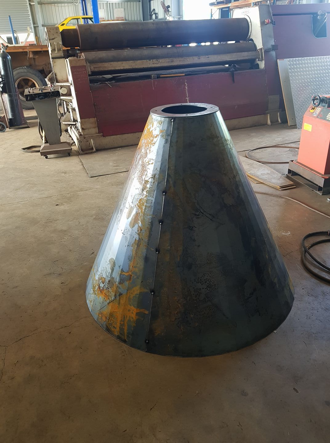 A Large Metal Cone is Sitting on the Floor in a Factory — Roll Press NT In Tivendale, NT