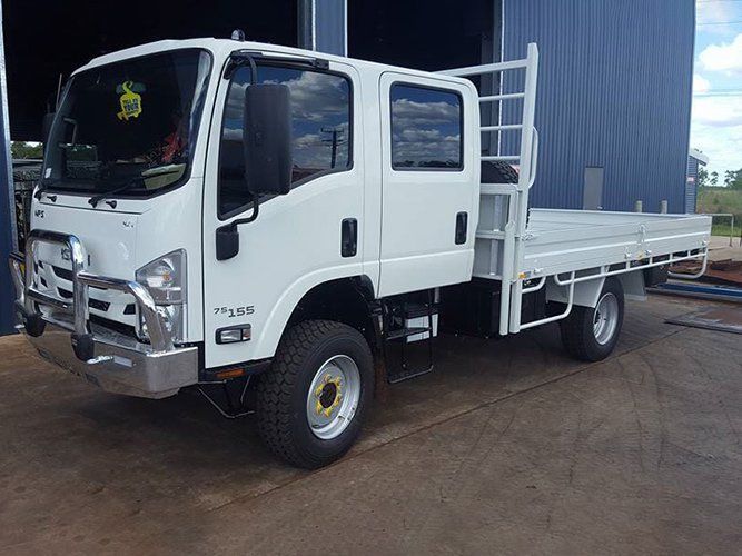 A White Truck With a Flat Bed is Parked in Front of a Building — Roll Press NT In Tivendale, NT