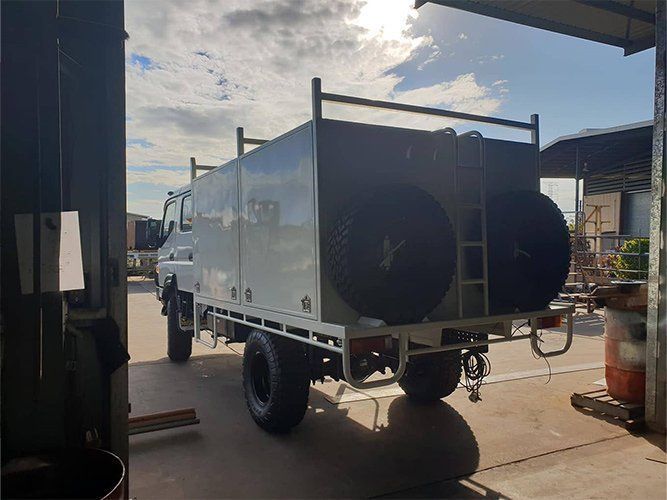 A Truck is Parked in a Garage Next to a Building — Roll Press NT In Tivendale, NT